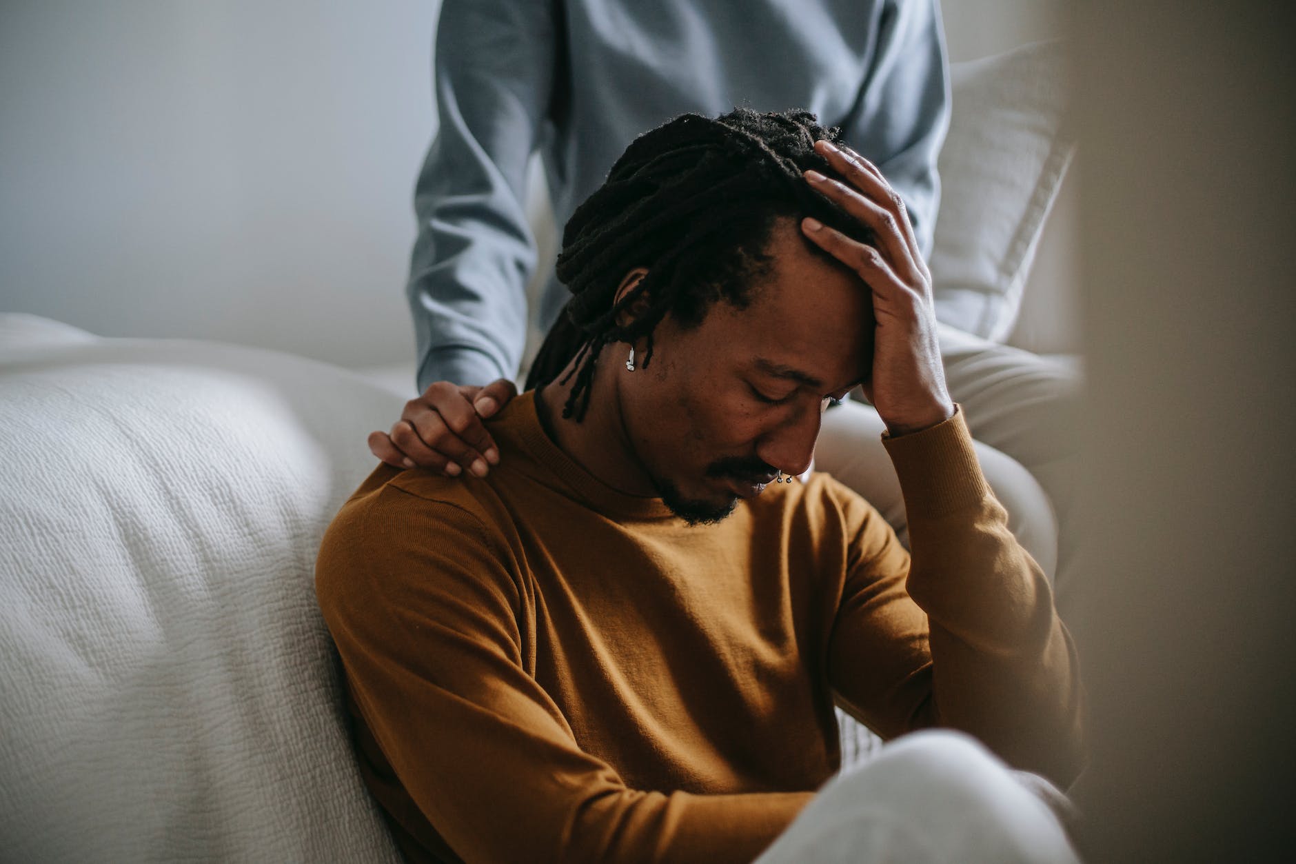 Sorrowful black man touching head in dismay near supporting wife. In the fourth of our key beats, it all falls apart and it looks like our hero might lose everything.