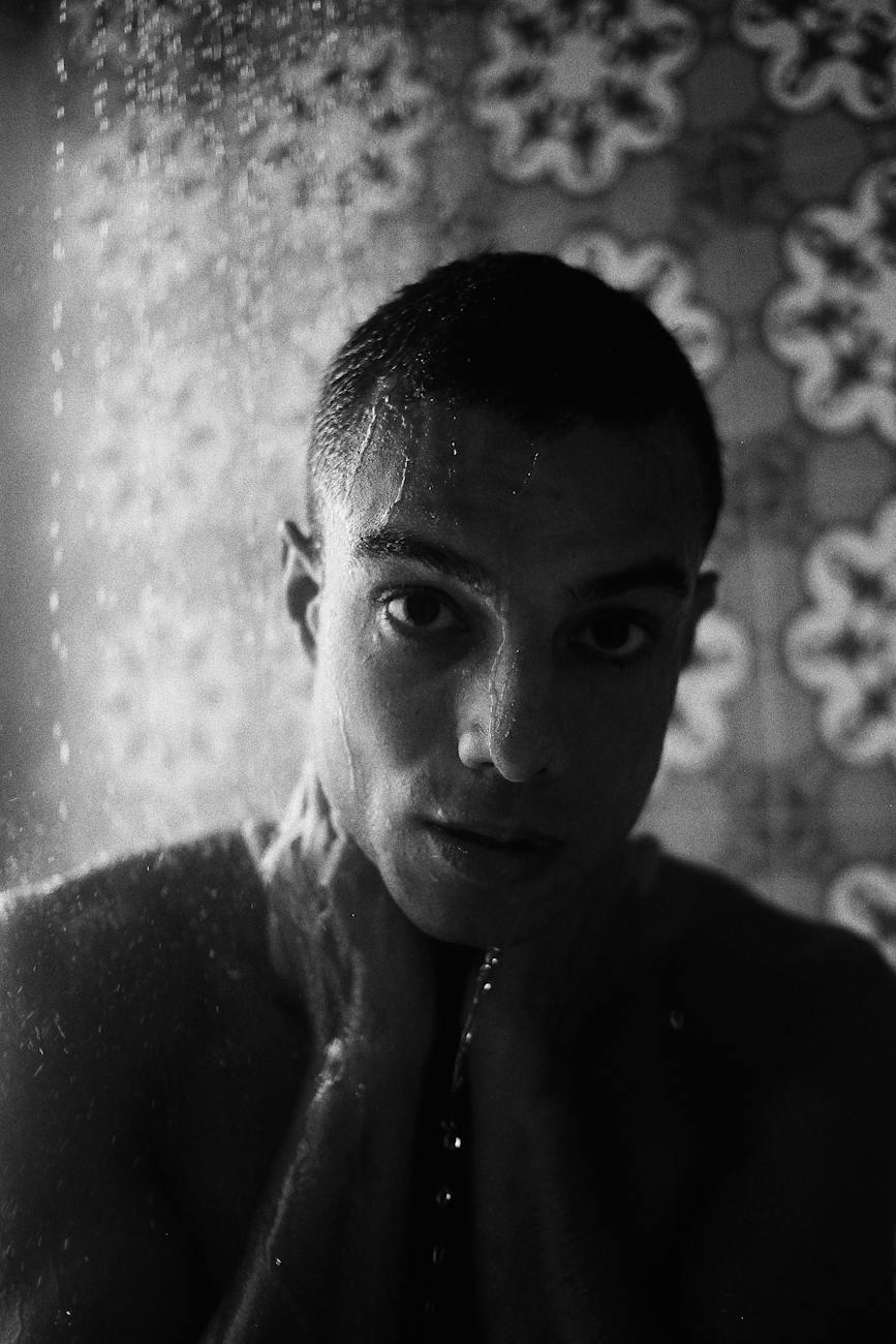 grayscale photo of man taking shower