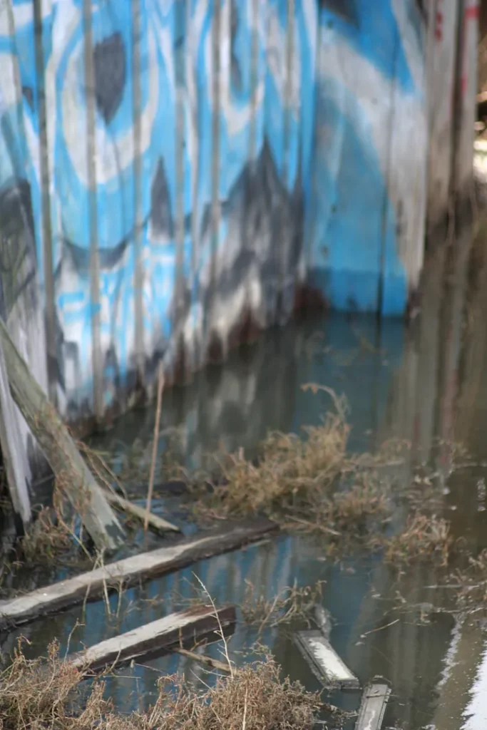 Water floods the floor of a broken down shack.