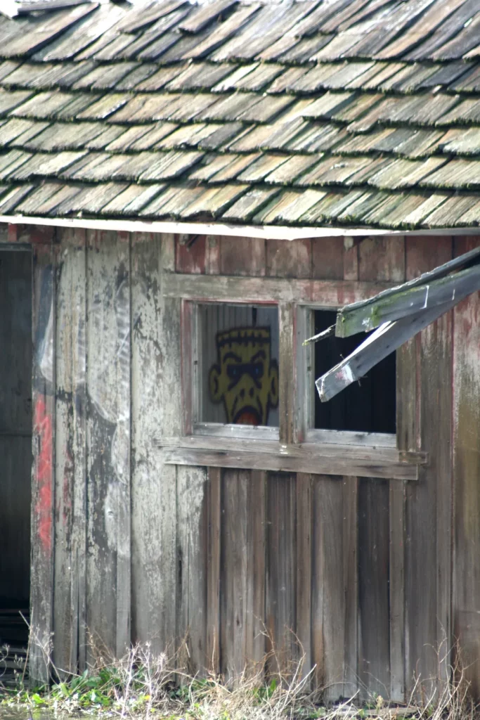 Graffiti inside a broken-down shack shows a cartoon of the Frankenstein monster.