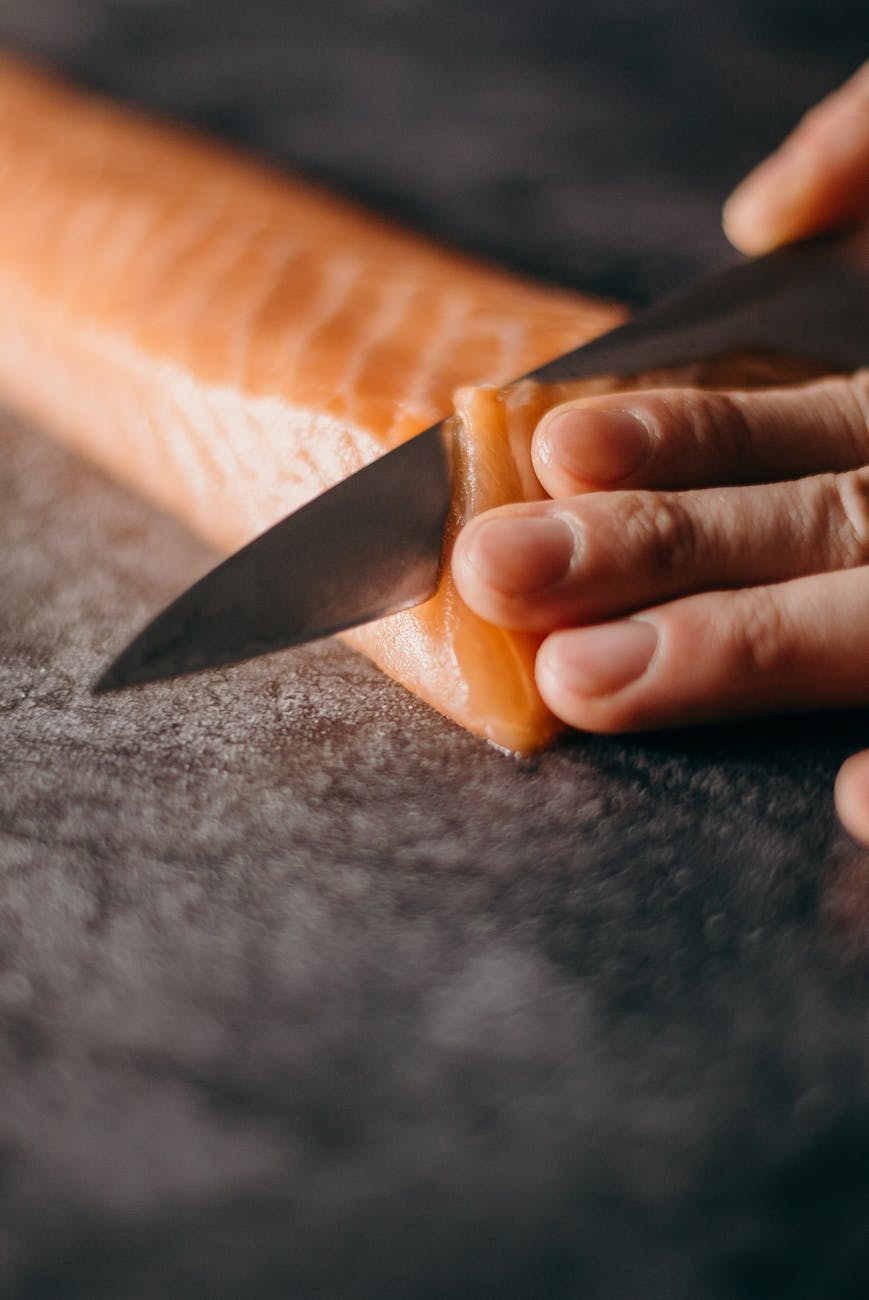 Photo of person slicing salmon.