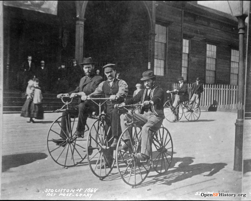 Three men riding bicycles.