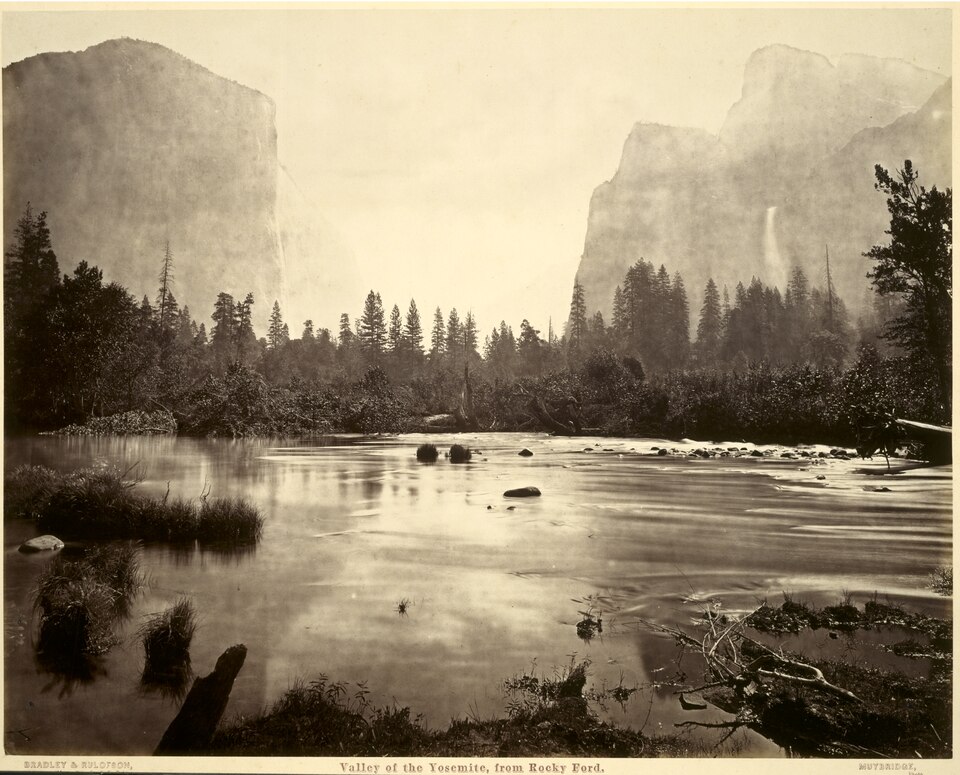 Tall cliffs to either side of a calm body of water.