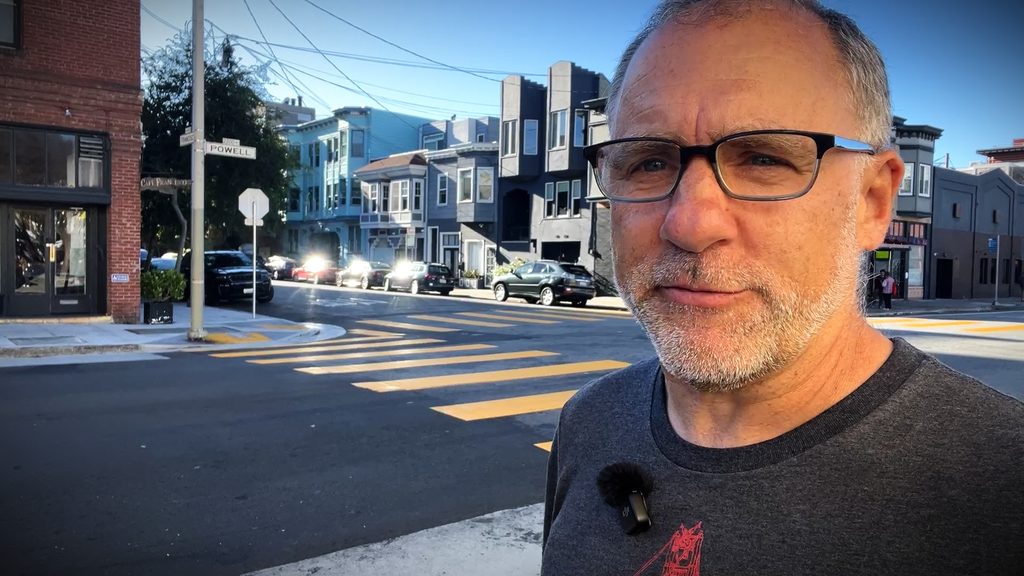 A man stands at the corner of Francisco and Powell streets in present-day San Francisco.