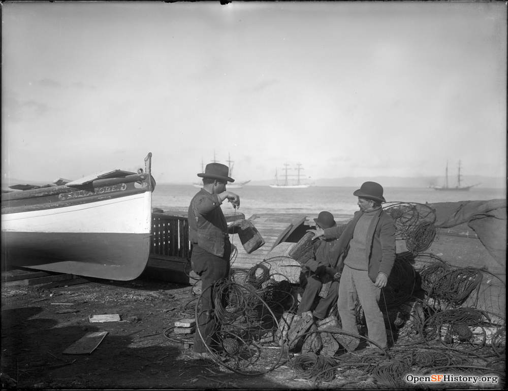 Fishermen with crab nets next to a dory.