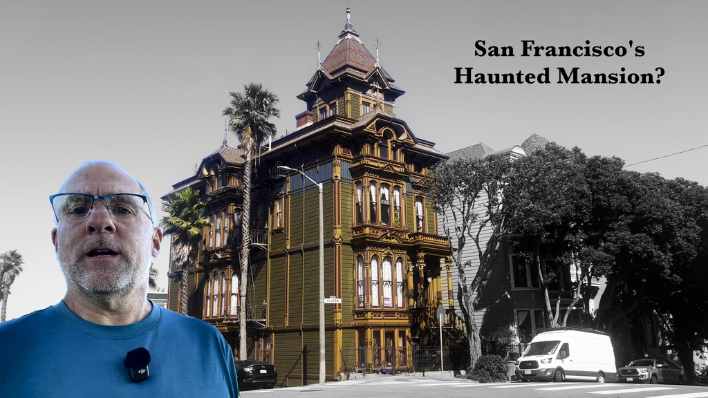 A man stands in front of a large, olive-green mansion, built in the Easlake Victorian style. Text reads, "San Francisco's Haunted Mansion?"